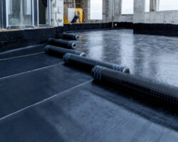 Laying and installation of roofing, bituminous waterproofing of an apartment building. Rolled roofing waterproofing of concrete slabs of stylobate. Heating and melting of bituminous roofing material.